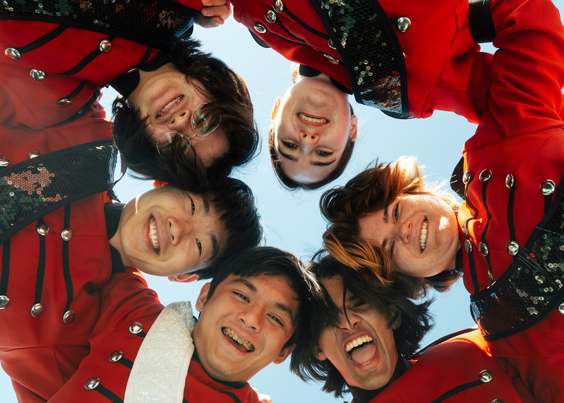 Marching band seniors laughing together in a huddle